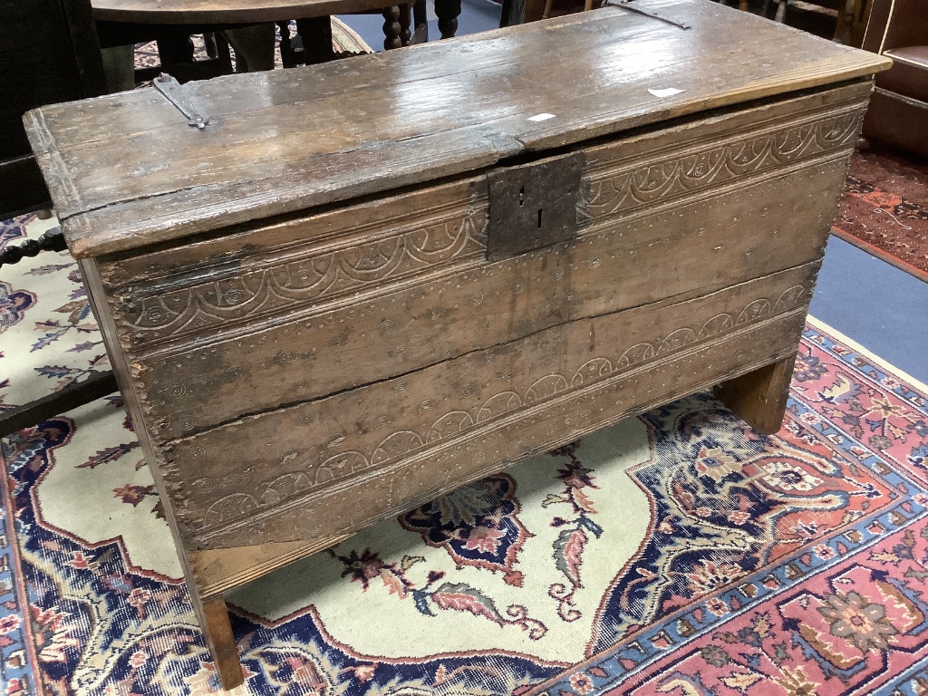 An early English oak six plank coffer, with shallow incised roundels and arched borders, 17th century, width 114cm, depth 50cm, height 72cm